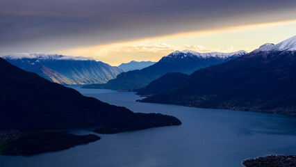 Fototapeta na wymiar Sun beams light the mountains over Como lake