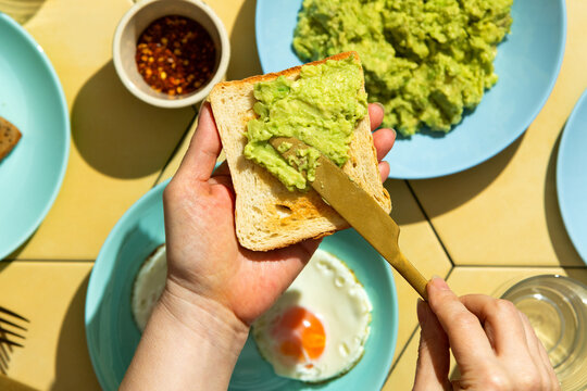 Spreading avocado guacamole on toast 