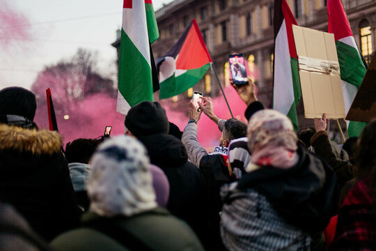 Crowd holding flags and smartphone at a rally