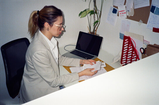 Focused woman working on laptop and counting receipts
