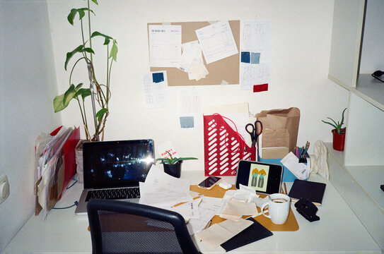 Interior of modern messy and chaotic workplace with laptop