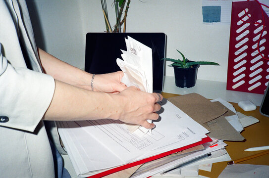 Crop faceless woman manages a stack of receipts in office