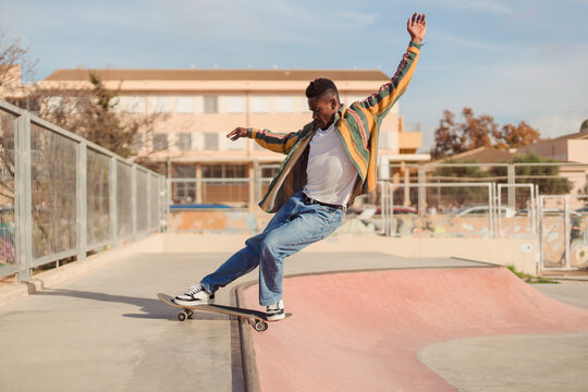 Active black man skateboarding on a ramp