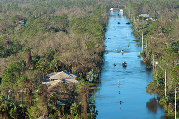 Flooded road in Florida after heavy hurricane rainfall. Aerial view of evacuating cars and surrounded with water houses in suburban residential area