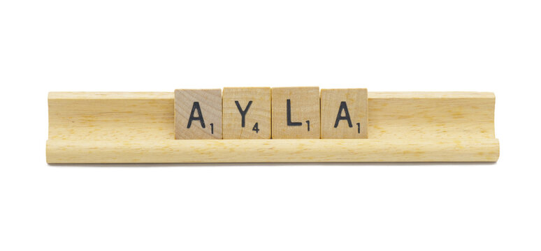 Miami, FL 4-18-24 popular baby girl first name of AYLA made with square wooden tile English alphabet letters with natural color and grain on a wood rack holder isolated on white background