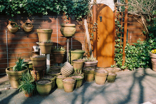 Garden pots and planters near wooden gate entrance