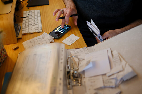 Man organizing receipts for his business tax report in home office