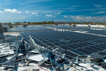Top view of destroyed by hurricane Ian photovoltaic solar panels mounted on industrial building...