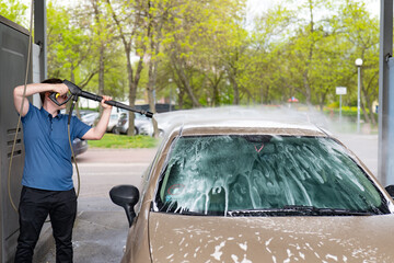 Person washing car. Washing the car with active foam