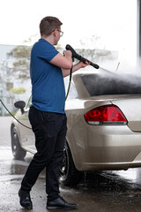 Man washing his car with high pressure water. Car wash concept.Cleaning car with high pressure water