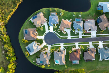 View from above of residential houses in living area in North Port, FL at evening. Illuminated American dream homes as example of real estate development in US suburbs