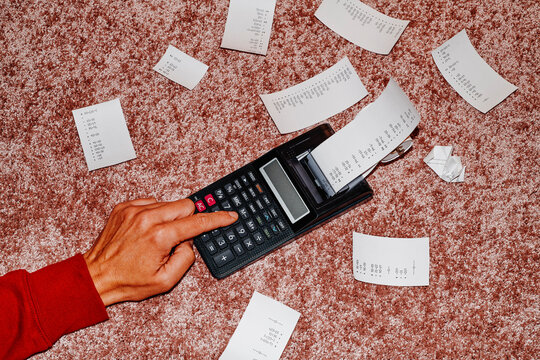 man using a calculator on the carpet