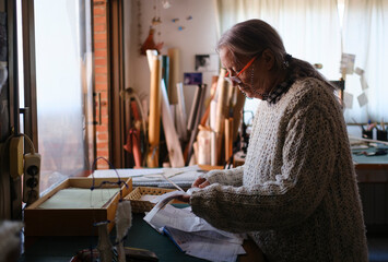 Woman organizing receipts for her business tax report in workshop