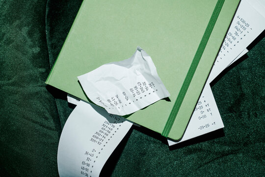 strips of paper with calculations peeking out of a notebook