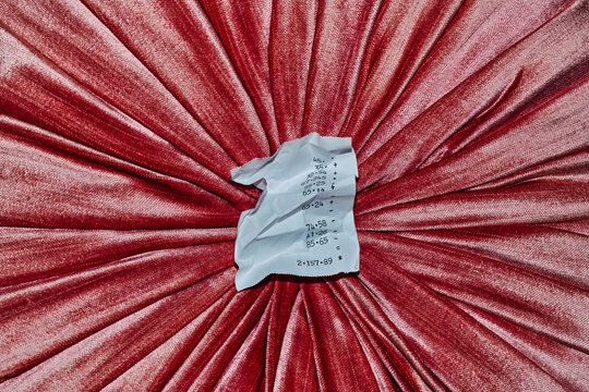 crumpled receipt on a ruched pink velvet fabric