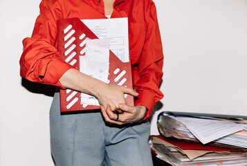 Crop business woman holding documents and files holder