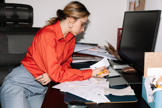 Young woman working and review and check a stack of receipts