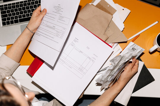 Crop woman accounting financial papers and receipts in office