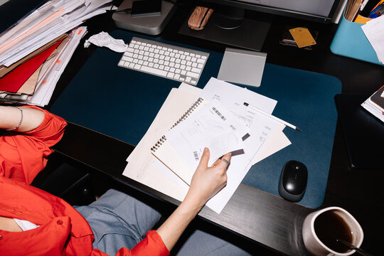 Crop woman hands working with business papers, invoices and receipts