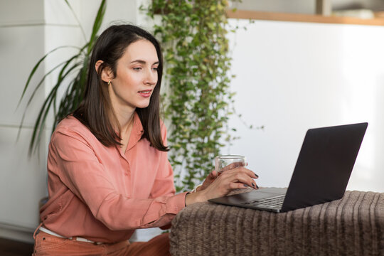 Woman in peach suit works from home