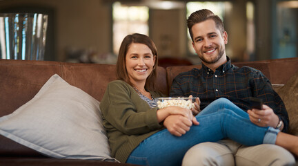 Portrait, home and couple with popcorn, relax and series with happiness, smile and entertainment in...