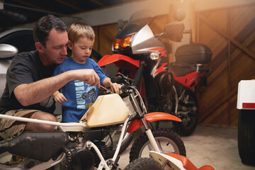 Parent, son and fixing with bike in garage at home for teamwork, support and repair with tools....