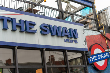 Fototapeta premium exterior building and sign of The Swan: A Firkin Pub located at 2205 Bloor Street West in Toronto, Canada