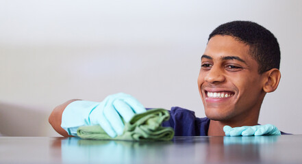 Young man, smile and cleaning a kitchen counter, housekeeping and disinfecting surface with cloth....