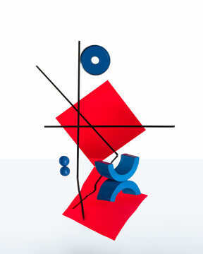 Abstract geometric still life in blue and red on reflective surface.