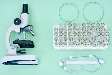 Lab, tools and collection of equipment with microscope, test tube and safety goggles for medical research. Science, medicine and laboratory supplies for pharmaceutical study on studio background.