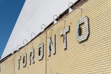 Fototapeta premium white brick relief sign on a yellow brick wall located at 550 Bayview Avenue (Evergreen Brick Works) in Toronto, Canada