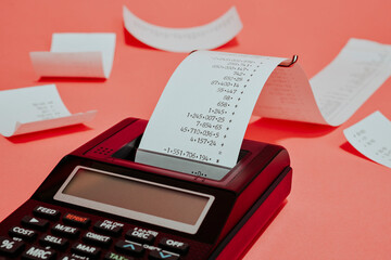 electronic calculator and strips of paper with calculations