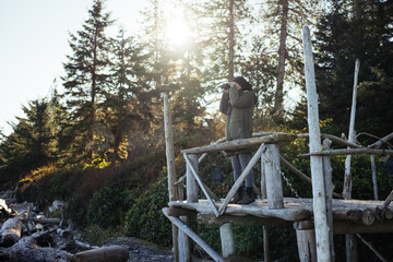 woman on platform using binoculars