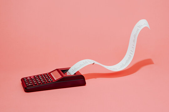 electronic calculator with paper-roll on a pink background