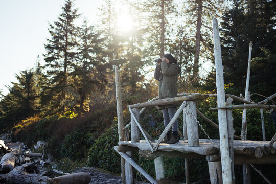 woman on platform using binoculars