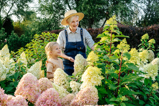 Grandmother teaching gardening granddaughter - Powered by Adobe