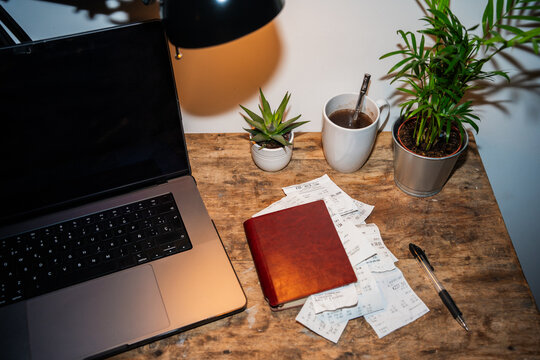 Desk With Receipts, Notebook And Computer.