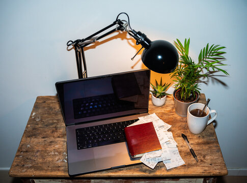 Desk With Receipts, Notebook And Computer.