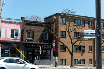 Fototapeta premium general view of shops and apartments along Mount Pleasant Road in Toronto, Canada (includes Starving Artist, a breakfast restaurant, located at 505 Mt Pleasant)