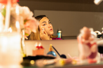 teen girl applying contouring makeup with  illuminator 