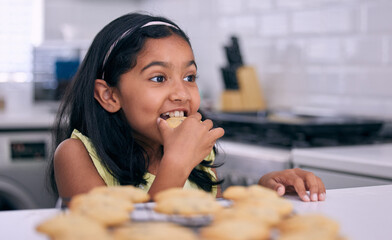 Girl, cookies and snack for bite in kitchen, hungry and organic biscuit or cake in home. Female...