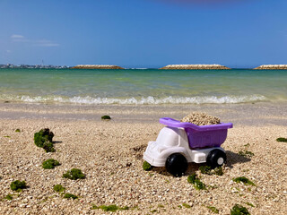 海辺の砂を積んだおもちゃのダンプカー
