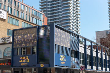Fototapeta premium exterior building and sign of Snakes & Lattes Midtown, a restaurant, located at 45 Eglinton Avenue East in Toronto, Canada
