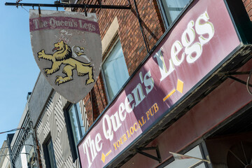 Fototapeta premium old street and building sign of The Queen’s Legs Local Pub located at 286 Eglinton Avenue West in Toronto, Canada