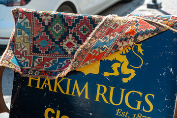 Fototapeta premium sidewalk sign with decorative carpet at Hakim Rugs located at 374 Eglinton Avenue West in Toronto, Canada