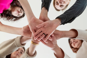 Smiling women stacking hands together