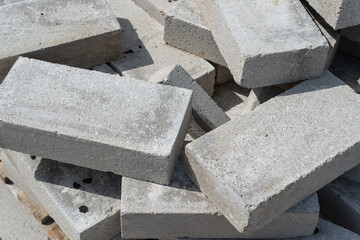 rectangular gray concrete blocks in a rough pile outside