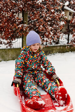Happy girl in the snow with a sledge