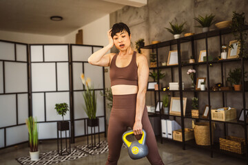 Fototapeta na wymiar Mature japanese woman exercise at home with kettlebell