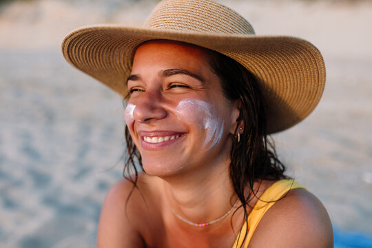 A Smiling Woman On the Beach With Sunscreen 